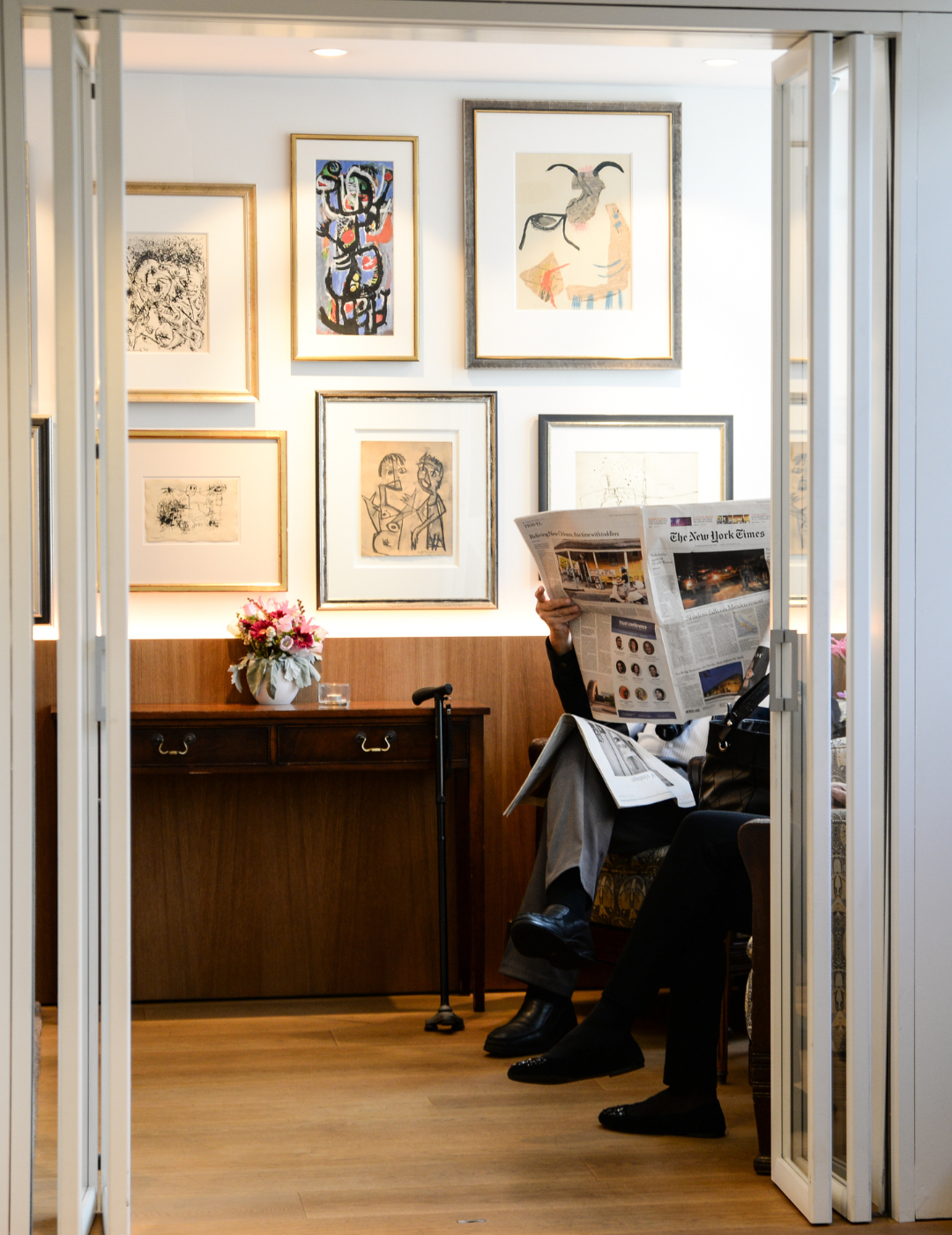 Gast liest eine Zeitung in der Cobra Lounge des Ambassade Hotels, umgeben von moderner Kunst.