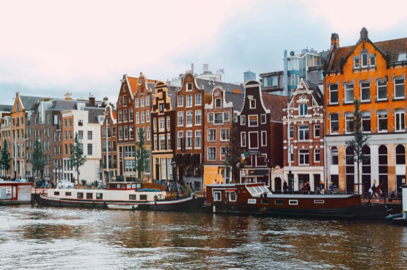 Vintage foto van een Amsterdamse gracht met historische gebouwen.
