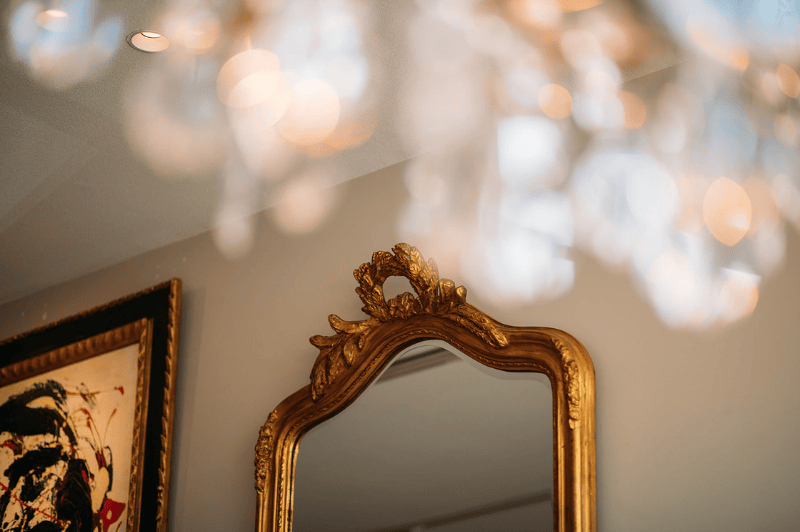 Decorative detail of a mirror and chandelier at the ambassade hotel in amsterdam, showcasing elegant interior design.