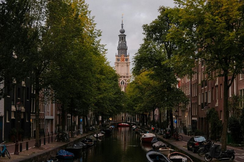 Vredige Amsterdamse gracht met reflecties van historische gebouwen in het water.