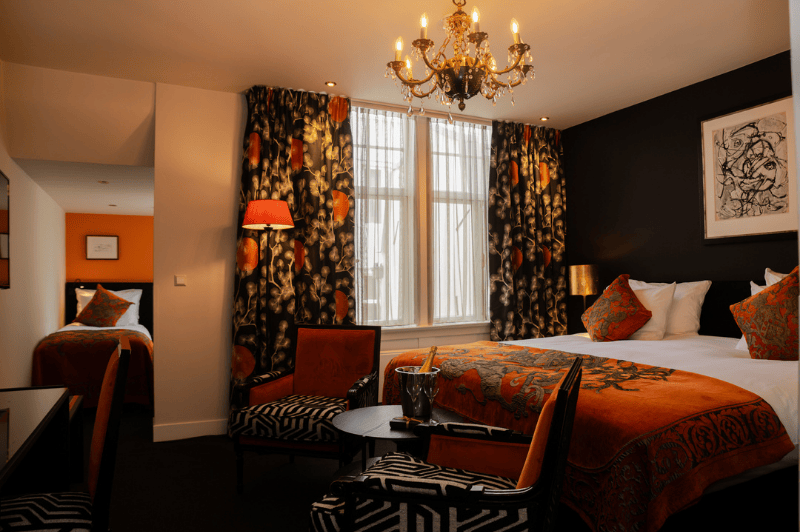 Spacious family room for four people at the ambassade hotel in amsterdam with comfortable beds and elegant interior.