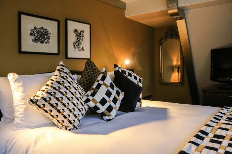 Elegant detail of the bed in the grand suite at the ambassade hotel in amsterdam, showcasing luxurious linens and refined design.