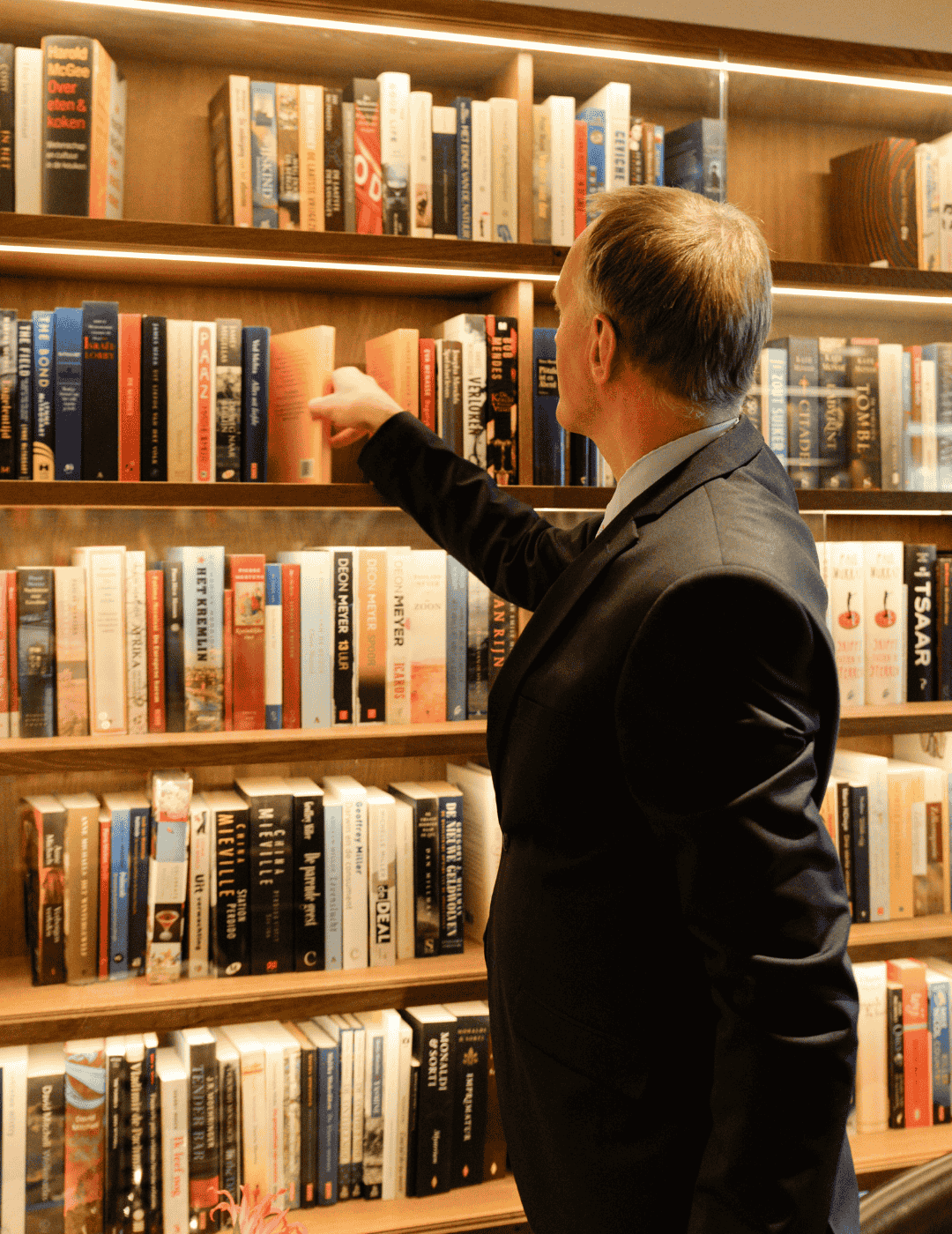 Librarian organizing books at the ambassade hotel library.
