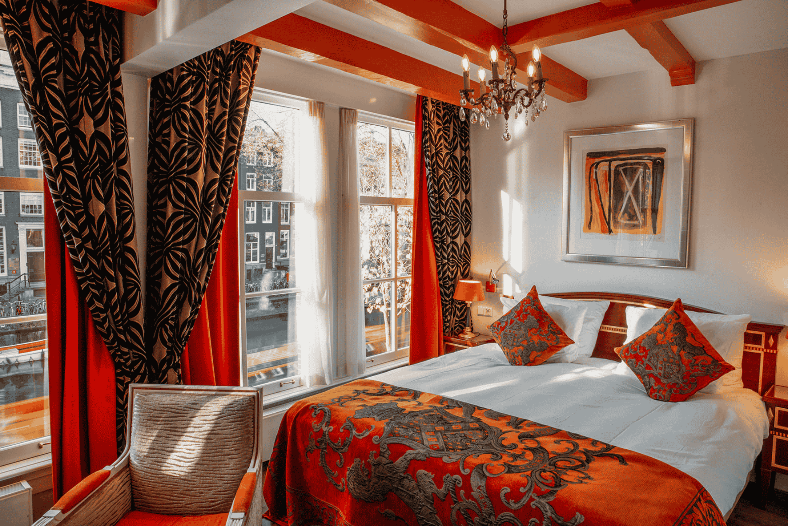 Superior deluxe canal view room with orange tones at the ambassade hotel in amsterdam, overlooking the herengracht.