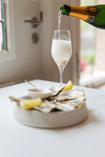 Cava and fresh oysters served at brasserie ambassade in amsterdam, perfect for a refined dining experience.