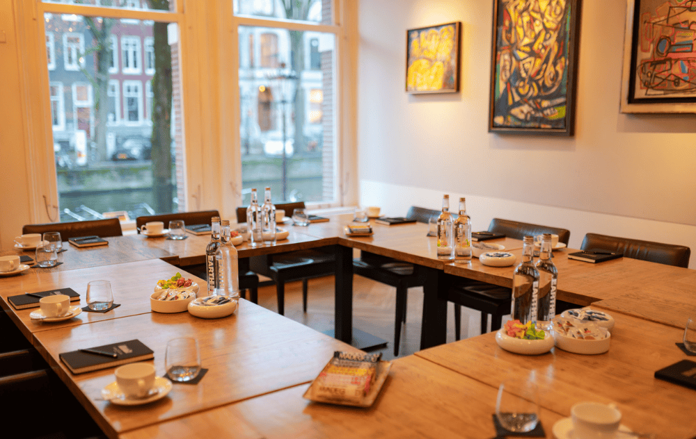 Alechinsky lounge at brasserie ambassade in amsterdam set up in u-shape for a meeting, surrounded by contemporary art.