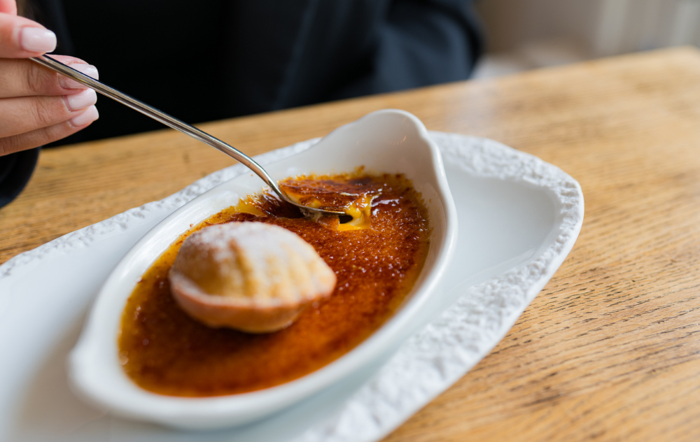 Classic crème brûlée dessert served at brasserie ambassade in amsterdam, with a golden caramelized top.
