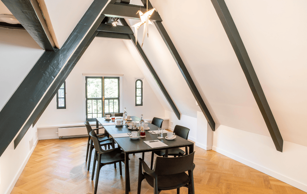 Meeting table setup in the attic at the ambassade hotel, an elegant and private space with historic charm.
