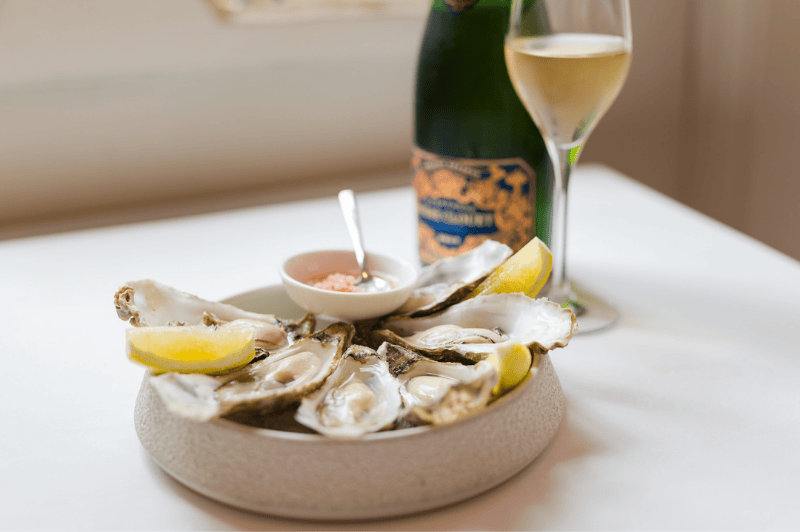 Fresh oysters served on ice at brasserie ambassade in amsterdam, accompanied by lemon and mignonette.