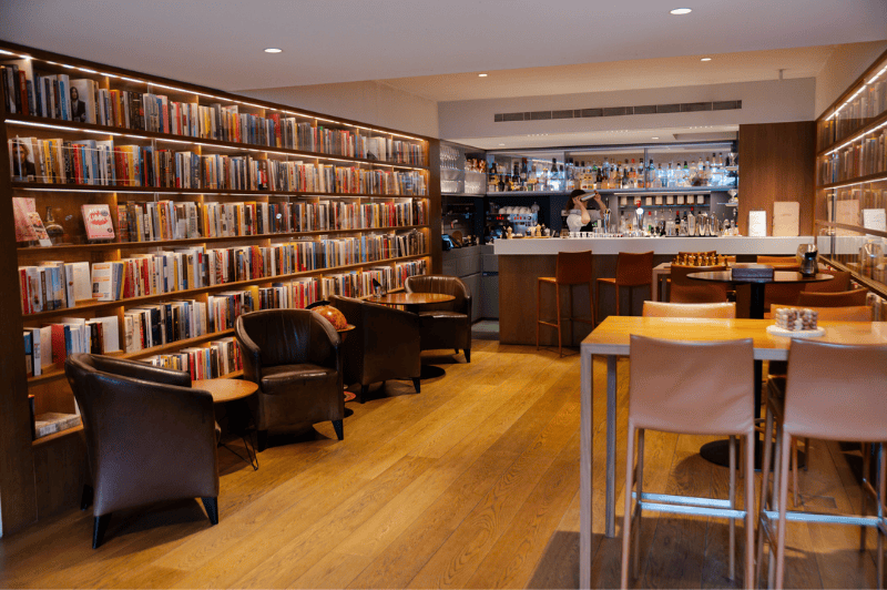 Cozy seating areas in the library bar at the ambassade hotel in amsterdam, featuring comfortable chairs and warm lighting.