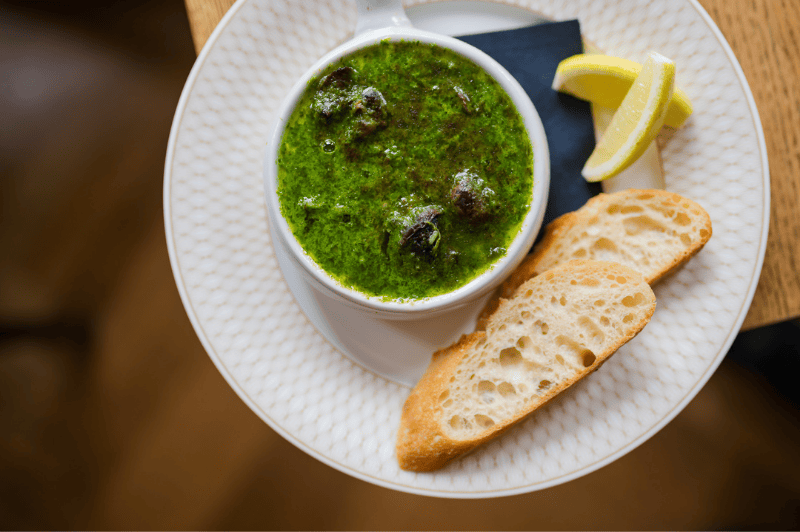 Escargots served at brasserie ambassade in amsterdam, prepared with garlic herb butter in classic french style.