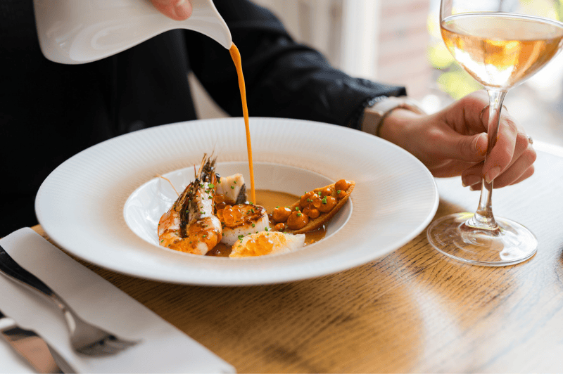 Serving bouillabaisse in a bowl at brasserie ambassade in amsterdam, showcasing classic french seafood cuisine.