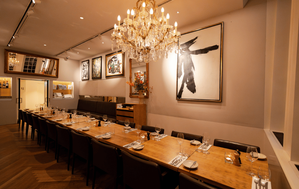 Wolvecamp lounge at brasserie ambassade in amsterdam with a long dining table set for an elegant private dinner.