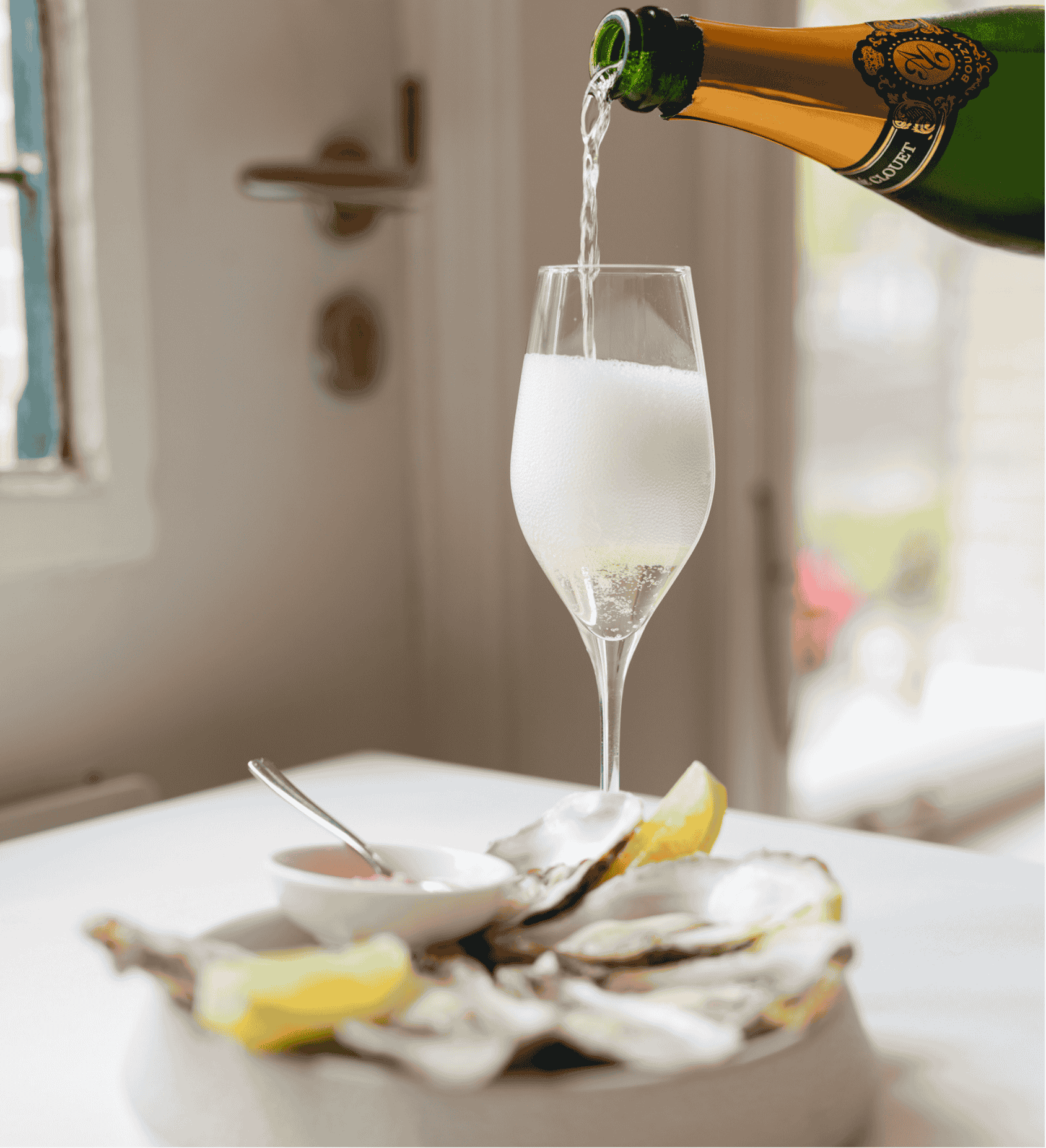 Glass of cava and fresh oysters served at brasserie ambassade in amsterdam, perfect for a refined dining experience.
