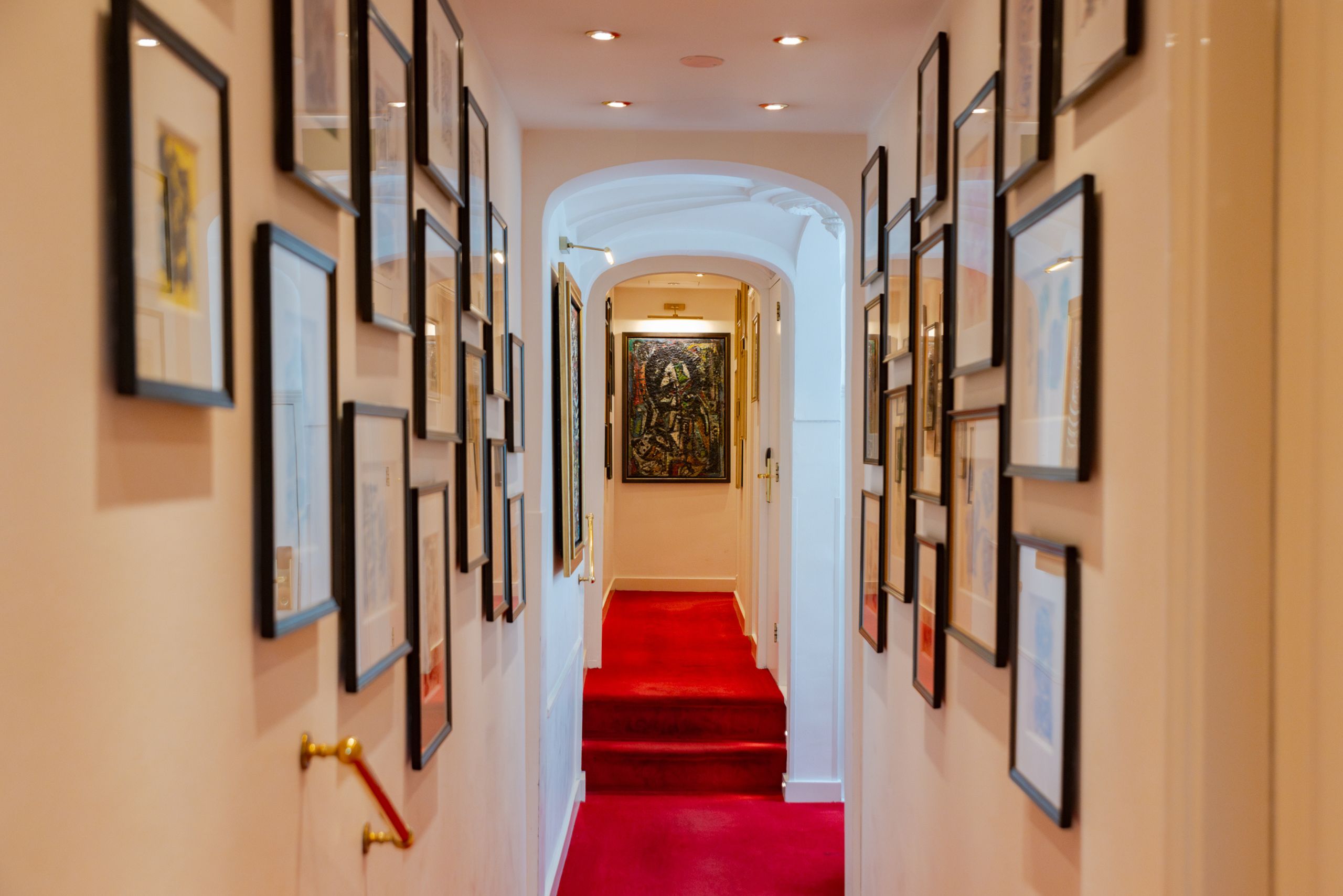 Couloir du premier étage de l'hôtel Ambassade avec des œuvres CoBrA de Wolvecamp sur les murs.