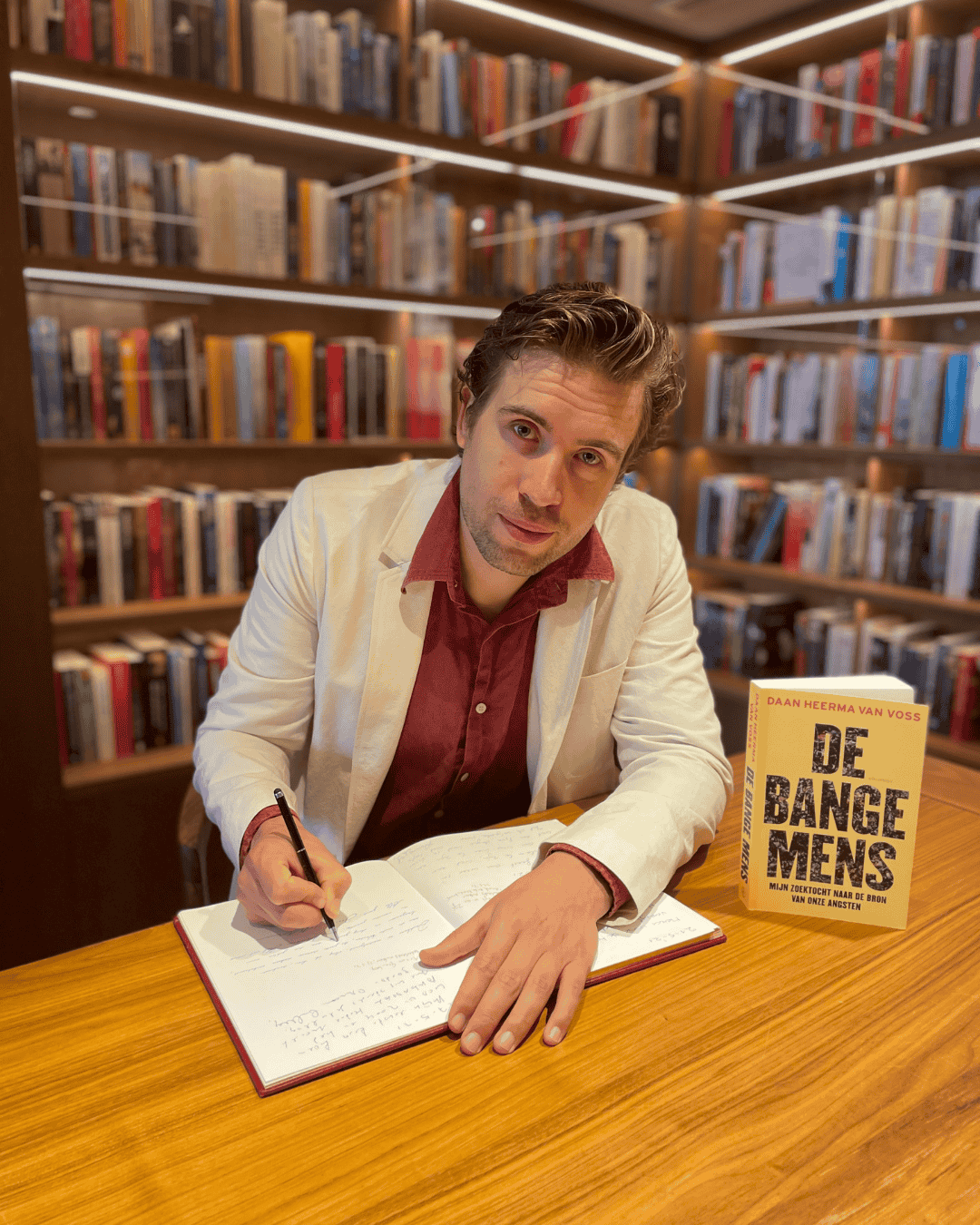 Autor Daan Heerma van Voss signiert sein Buch De bange mens im Ambassade Hotel für die Hotelbibliothek.