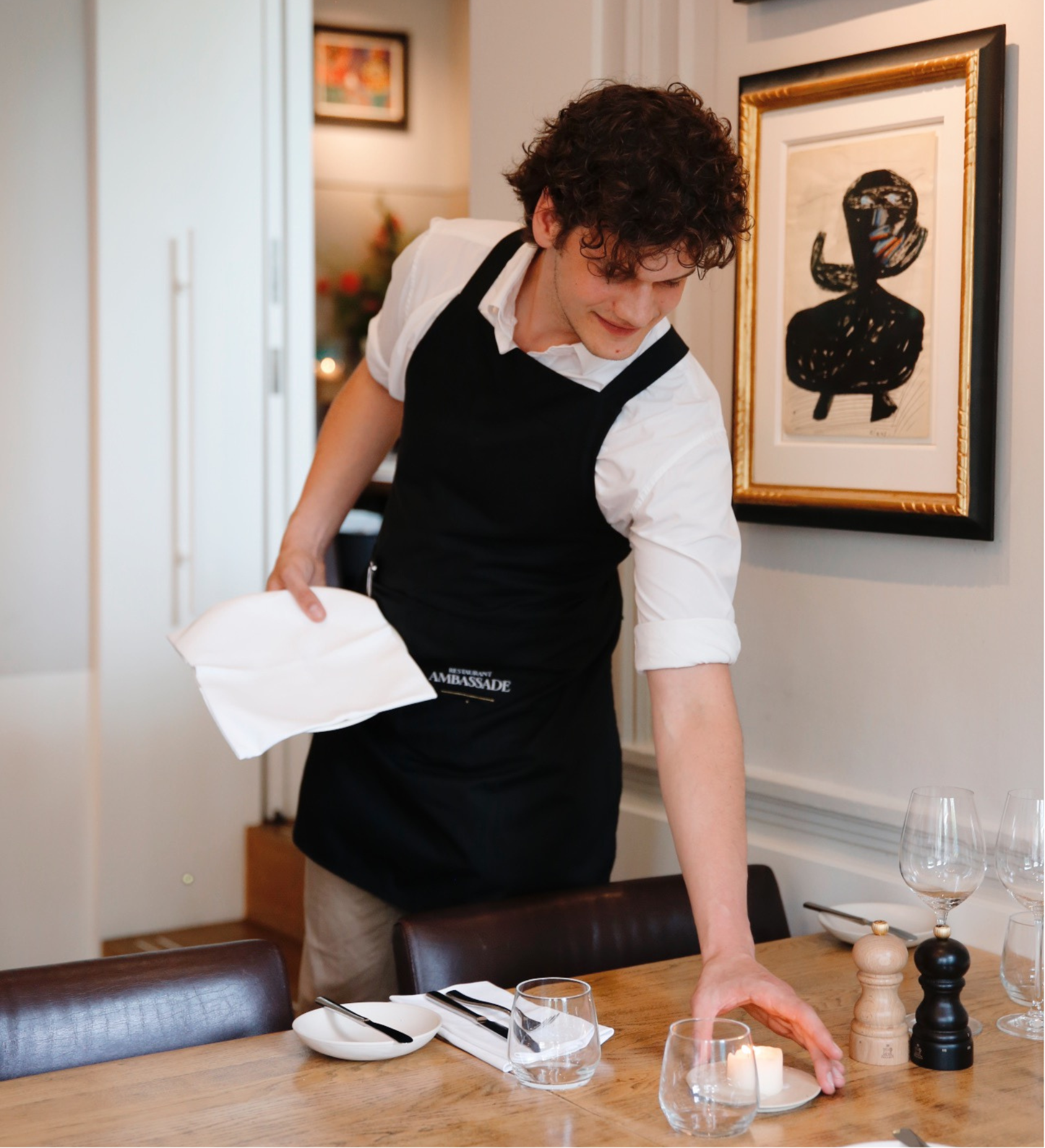 Staff member setting the table in the brasserie at the ambassade hotel.